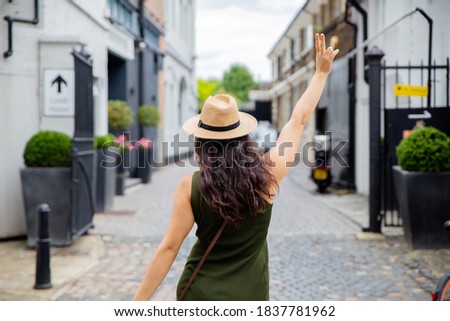 Landscape View of a Joyful Woman in Green Dress From Behind Posing in front of an Alley Entrance from London, UK