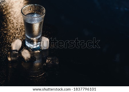 Vodka. Shots, glasses with vodka with ice .Dark background. Copy space .Selective focus