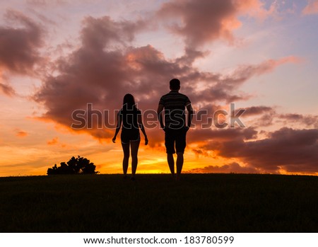 Silhouette of couple enjoying beautiful sunset in Hawaii.