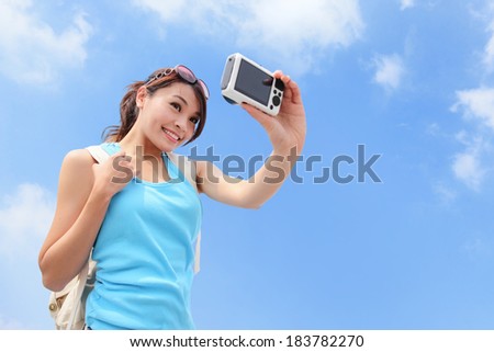 Happy woman traveler photo by camera with blue sky