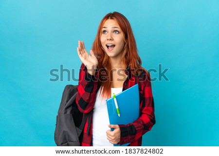 Teenager student Russian girl isolated on blue background with surprise facial expression
