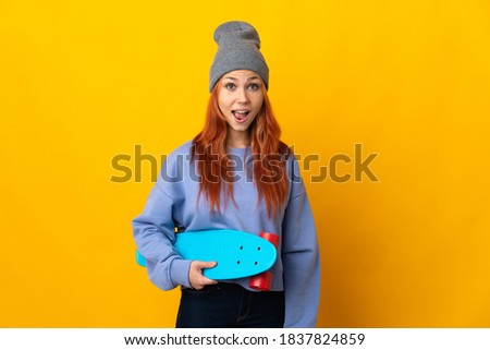 Teenager Russian skater girl isolated on yellow background with surprise facial expression