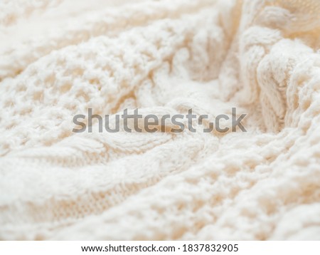 Hand made cable-knit sweater sweater. Texture of warm knitted fabric with pattern. White crumpled cardigan. Cozy autumn outfit for snuggle weather.  Royalty-Free Stock Photo #1837832905