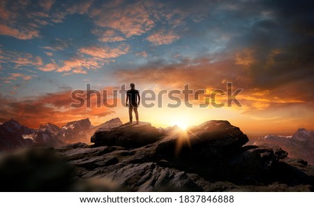 A man standing at the top of a mountain as the sun begins to set. Goals, hopes and aspirations concept. Photo compostion. Royalty-Free Stock Photo #1837846888