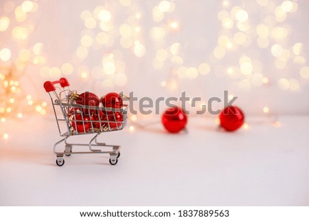 Food basket with red Christmas balls on the background of glowing lights. New year's sale concept