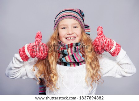 Happy child in christmas. Girl in winter clothes. Studio shot