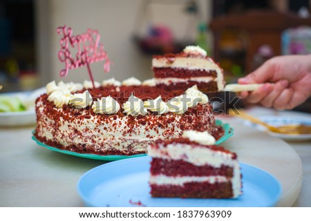 A slice of Red Velvet cake on blue plastic plate top of table