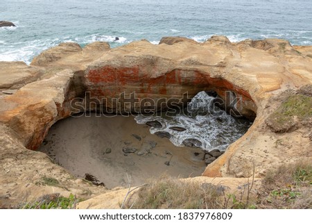 USA, Oregon, Otter Rock. Devil's Punchbowl beginning to fill as tide comes in.