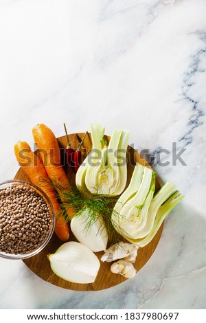 vegetables for broth and lentils on the table: onions, garlic, carrots, fennel, hot peppers. Basic Cooking Plants