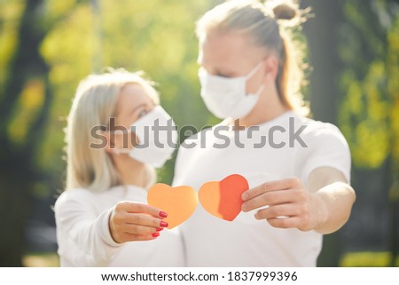 Couple with red heart wearing protective masks during coronavirus and flu outbreak. Virus and illness protection. 