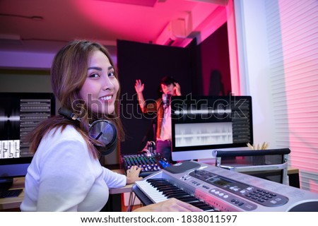 Producer of young handsome singer man happy and motivated, singing a song with a microphone in the studio. Enjoy in the moment and happiness. Soft focus and blur