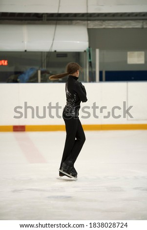 Figure skating school. Female skater practicing at indoor skating rink. Woman learning to ice skate.