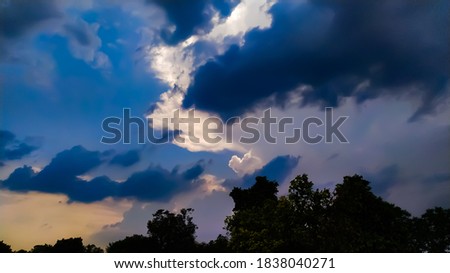 evening time sky blue black clouds gold multiple colours beautifully evening whether in indian village wether