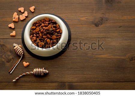 Dry cat food in bowl with toy, top view