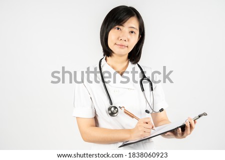 Portrait of young Asian nurse with a stethoscope who writing medical record. The nurse record the document in paperwork in the hospital