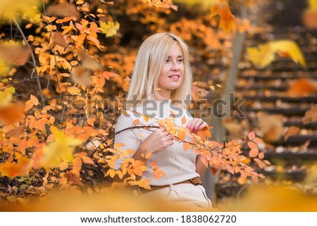 Woman enjoying autumn weather. Autumn portrait of a girl. Walk through the autumn park.