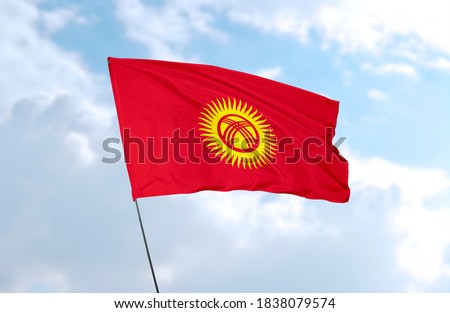Flag of Kyrgyzstan in front of blue sky