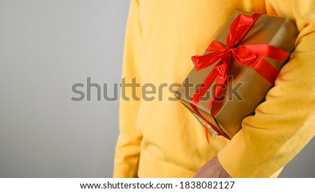Man in a yellow sweater gift wrapping