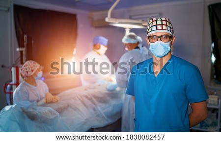 Male medical specialist portrait. Modern equipment in operating room. Medical devices for neurosurgery. Background. Operating theatre. Selective focus.