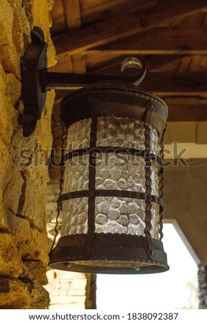 An old iron street lamp on wall made of decorative stone. Vertical photo