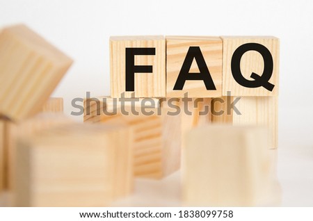 Wooden blocks with the word FAQ on a white table. in the foreground cubes in a blurred background. Frequently asked questions about the concept. High quality photo