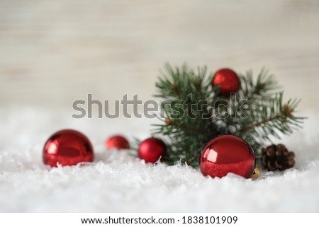Beautiful Christmas balls and fir branch on snow
