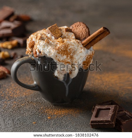 Hot chocolate cocoa cup with whipped cream decorated with cinnamon, chocolate slices and cookies  on concrete background. Tasty beverage for cold days .