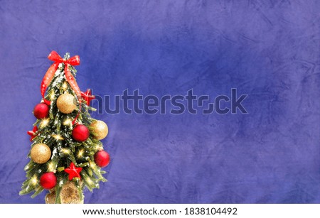 Christmas tree with red and gold balls on a blue background. Christmas decor. Festive background with place for text.