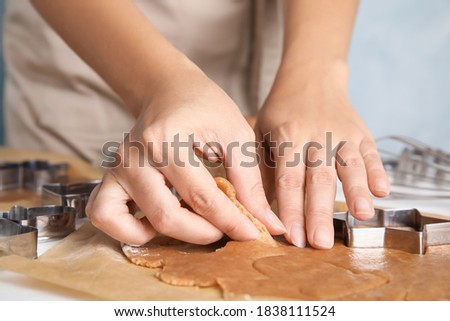 Woman making Christmas cookies at table, closeup