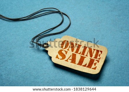 online sale - a paper price tag against blue background - internet shopping concept