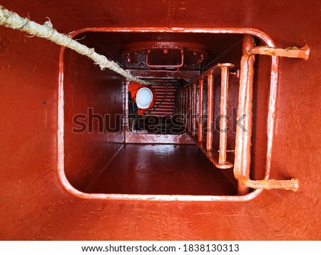 a man or ship crew in the manhole or  cargo hold entrance. enclosed space. confined space.  Royalty-Free Stock Photo #1838130313