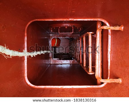 a man or ship crew in the manhole or  cargo hold entrance. enclosed space. confined space.  Royalty-Free Stock Photo #1838130316