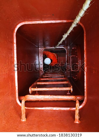 a man or ship crew in the manhole or  cargo hold entrance. enclosed space. confined space.  Royalty-Free Stock Photo #1838130319