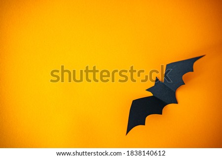 Holidays concept - Halloween paper decorations and sweets with blank copy space over orange background. Flat lay of accessory decoration