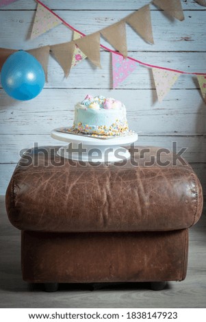 Birthday Cake On Leather Foot Stool With Decorations
