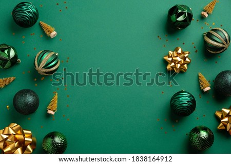 Christmas green background with baubles and golden decorations. Xmas frame with copy space. Greeting card mockup, banner template. 