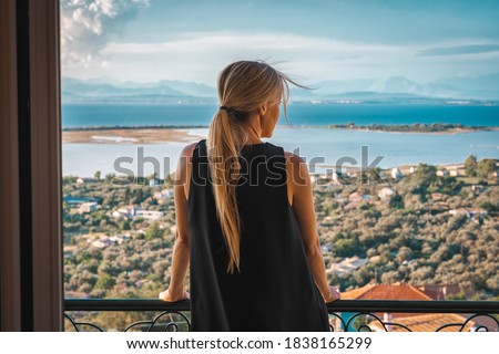 Young woman on seaside hotel balcony Royalty-Free Stock Photo #1838165299