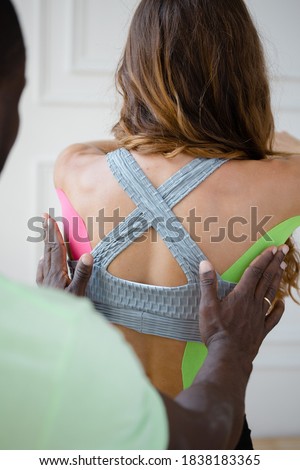 Back view. Woman athlete with kinesio tape on her back. Kinesio taping