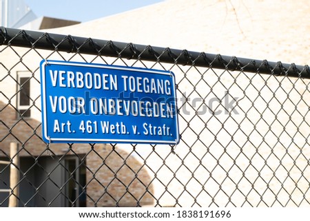 Sign attached to a fence with the Dutch text 'no entry for unauthorized persons, article 461 penal code'