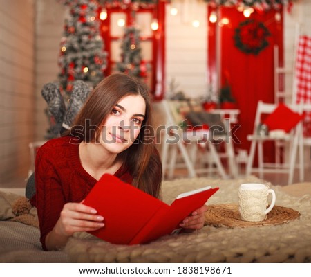 Young girl in a New Year's Eve at home with a book lying on the bed, waiting for a miracle