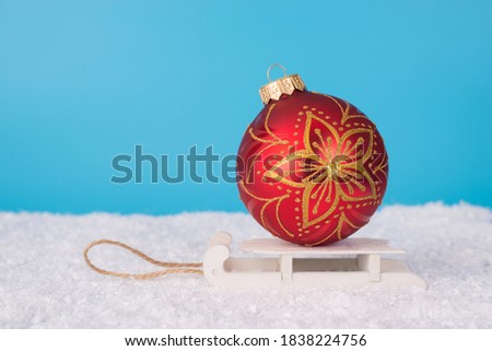 Merry Christmas scene concept. Close up side profile view photo of beautiful large round bright color with flower decor bauble carried by wooden sledges in winter time outside