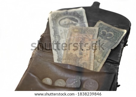 Vintage leather wallet with old Soviet money from the mid-twentieth century. Banknotes and coins. White background. Shallow depth of field