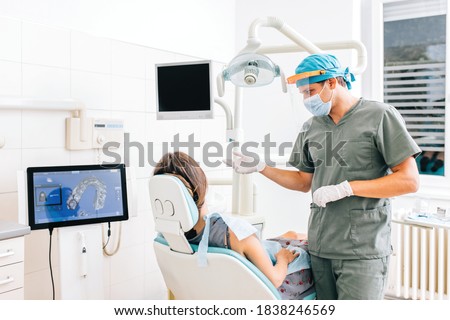 Dentist with female patient in a modern dental clinic explaining the procedure. Dentistry concept. Royalty-Free Stock Photo #1838246569