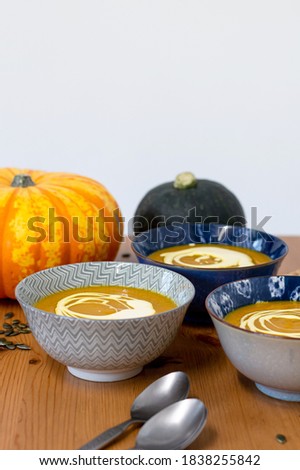 pumpkin soup in grey and navy bowls