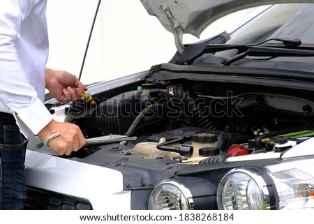 Man checking the car engine and master repairs under the hood of the car, and car insurance concept 