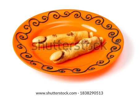 Spooky Halloween witch finger cookies in the plate, isolated on the white background