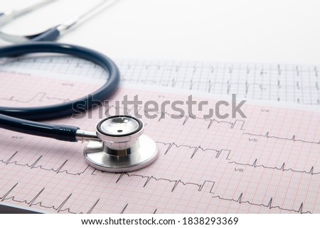 Blue Stethoscope on electrocardiogram (ECG) chart paper. ECG heart chart scan isolate on white. Healthcare insurance and medical background  Royalty-Free Stock Photo #1838293369