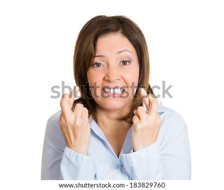 Closeup portrait, young woman, crossing her fingers, hoping for best future, looking at you, camera, in anticipation of life changer, isolated white background. Human emotion, facial expression, signs