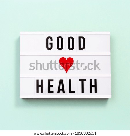 Healthcare and medical concept. Lightbox with words Good Health on mint colored background. Health wishes. Top view.