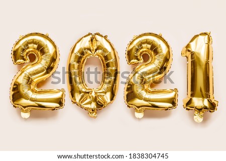 Close-Up gold foil balloons numeral 2021 on beige background. Merry Christmas and happy new year concept.